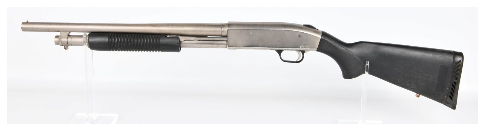Mossberg 500A Mariner 12 Gauge Pump-Action Shotgun with 18? Inch Barrel: A Mossberg 500A Mariner 12 Gauge pump-action shotgun, featuring a silver-colored metal barrel, receiver, and magazine tube, contrasted with black synthetic furniture including the stock and ribbed for