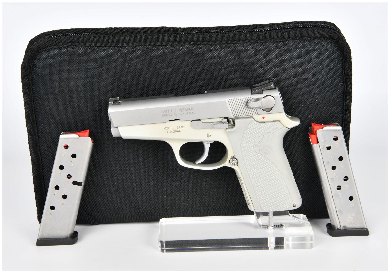 Smith & Wesson Model 3913 Lady Smith 9mm Semi-Automatic Pistol: A Smith & Wesson Model 3913 Lady Smith 9mm semi-automatic pistol, featuring a two-tone design with a silver-colored metallic slide and an off-white polymer or alloy frame. The frame is fitted with mat