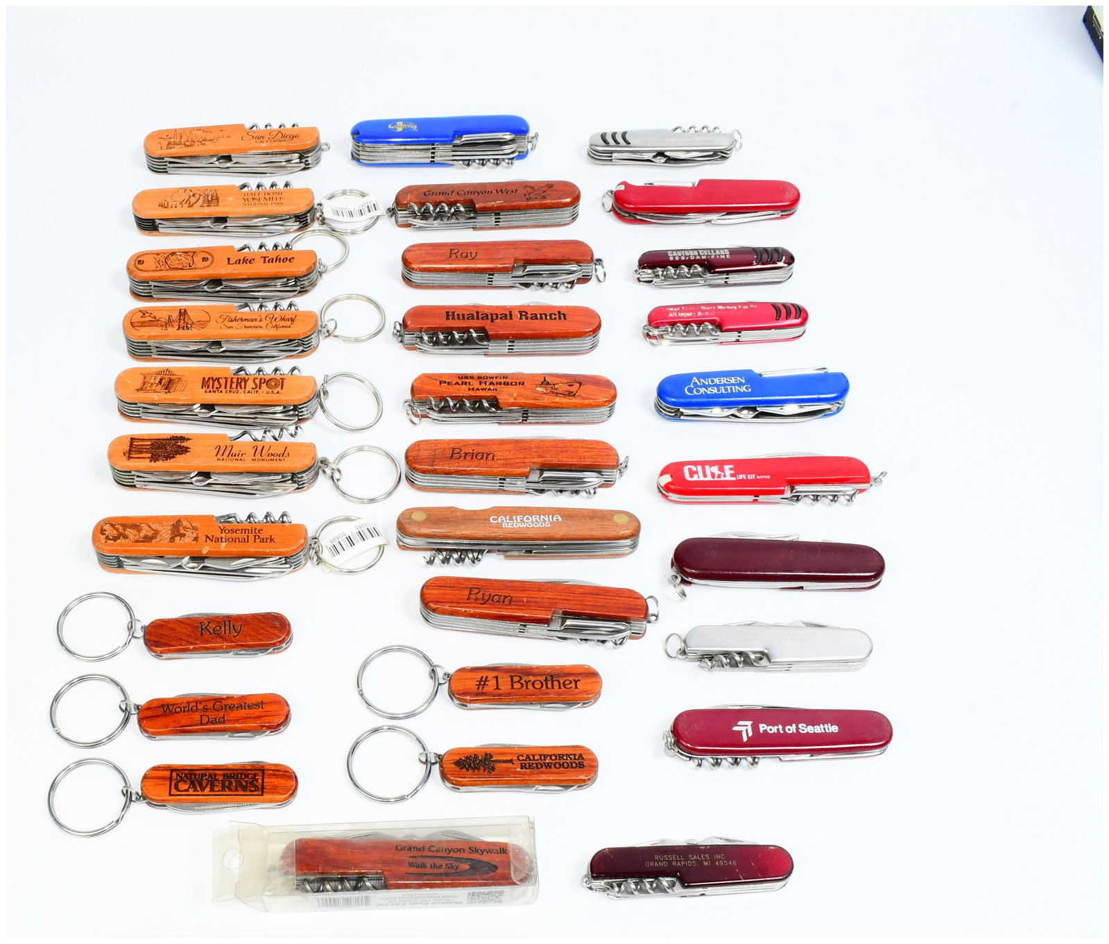 A Collection of Approximately 40 'Swiss Army Style' Multi-Tool Pocket Knives, Likely TSA Confiscated: A collection of approximately 40 multi-tool pocket knives, consistent with those often found in 'TSA Confiscated' lots. The knives are designed in a Swiss Army style and many feature attached keyrings