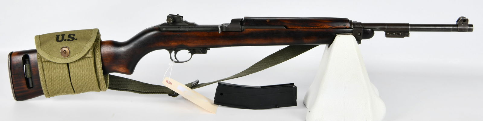 WWII U.S. Winchester M1 Carbine, .30 Caliber: A WWII U.S. Winchester M1 Carbine, .30 Caliber. This military-style semi-automatic carbine is constructed with a dark reddish-brown wooden stock and various dark grey metal components. It is accompani
