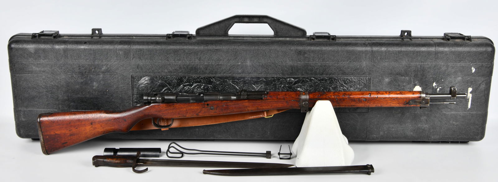 Japanese Type 99 Arisaka Bolt-Action Military Rifle with Bayonet and Accessories: A Japanese Type 99 Arisaka bolt-action military rifle, featuring a blued steel action and barrel, paired with a dark stained wooden stock. The receiver is marked with '???' (Type 99) and an adjacent c