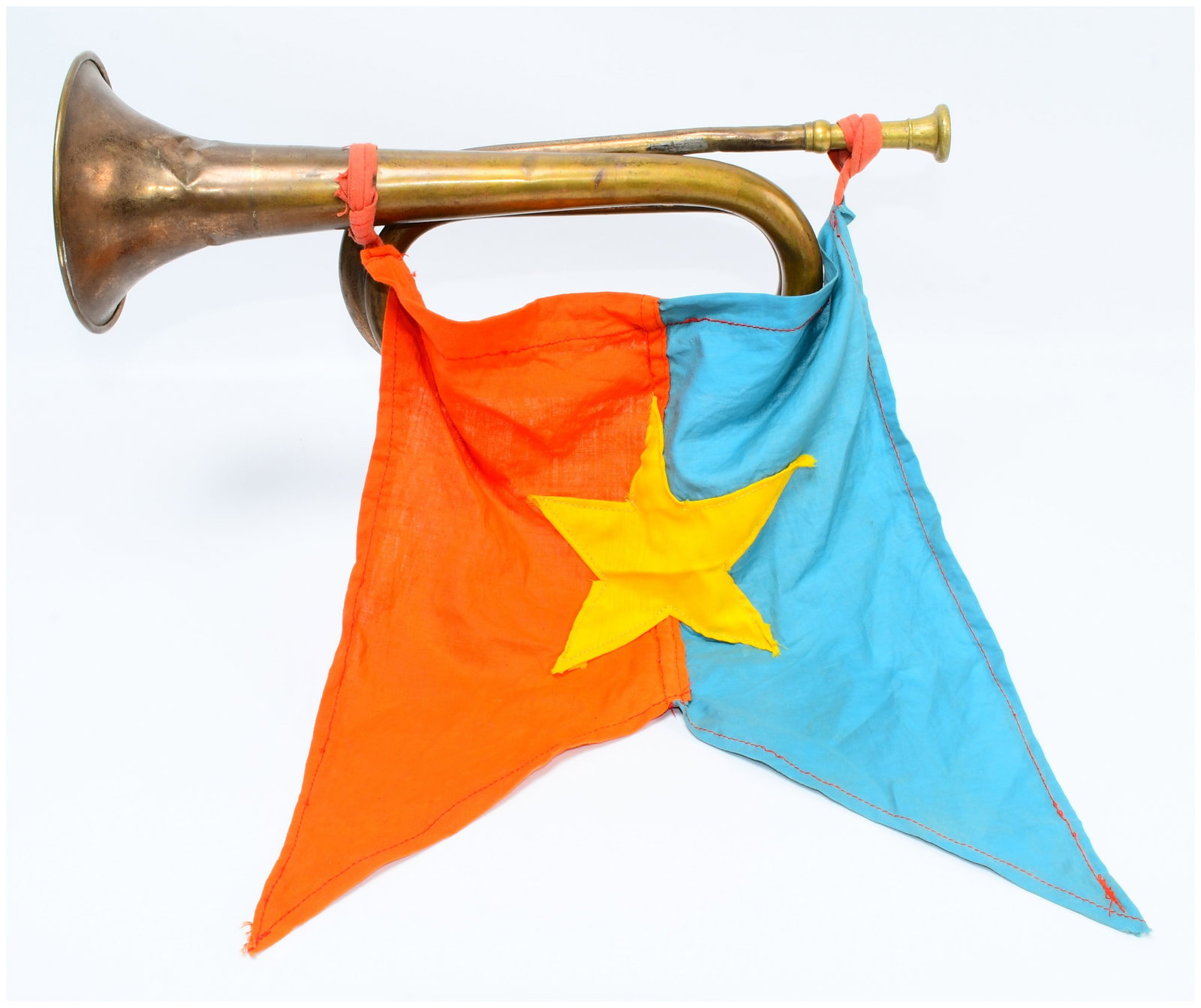 Vietnam War Era North Vietnamese Army (NVA) or Vietcong (VC) Brass Bugle with Attached Pennant: A Vietnam War Era North Vietnamese Army (NVA) or Vietcong (VC) brass bugle with an attached swallowtail pennant. The bugle exhibits a heavily tarnished and patinated finish, consistent with significan
