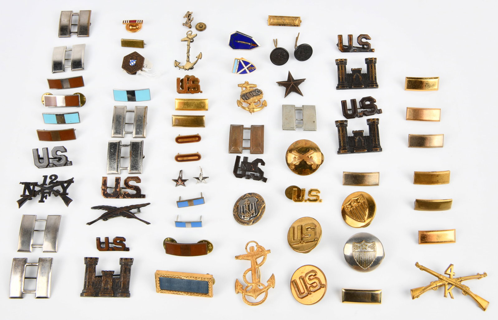 A Collection of United States Military Insignia and Pins, Predominantly 20th Century: A collection of approximately 60 individual pieces of United States military insignia, badges, and pins, predominantly from the 20th century, including the WWII era. The items are largely metal and fe