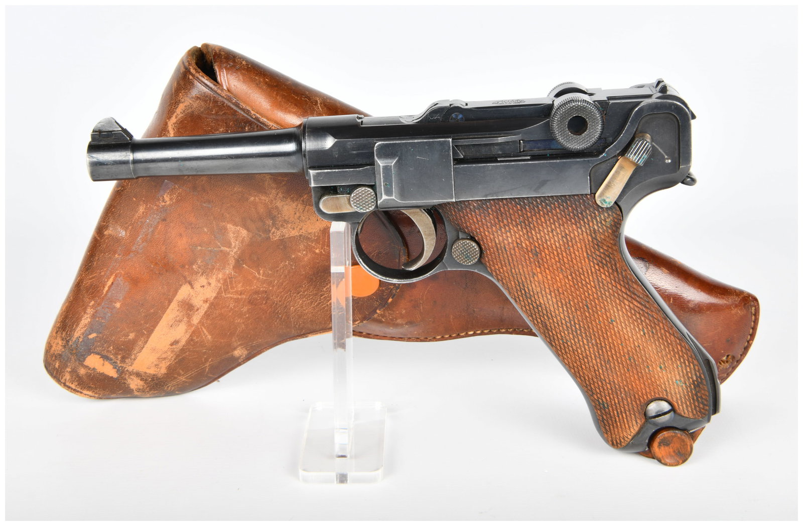 DWM Luger P08 9mm Semi-Automatic Pistol with Holster and Magazine: A DWM Luger P08 9mm semi-automatic pistol. This blued steel pistol features textured wooden grip panels and a distinctive toggle-lock action. Visible markings include "GESICHERT" (German for "SAFE") o