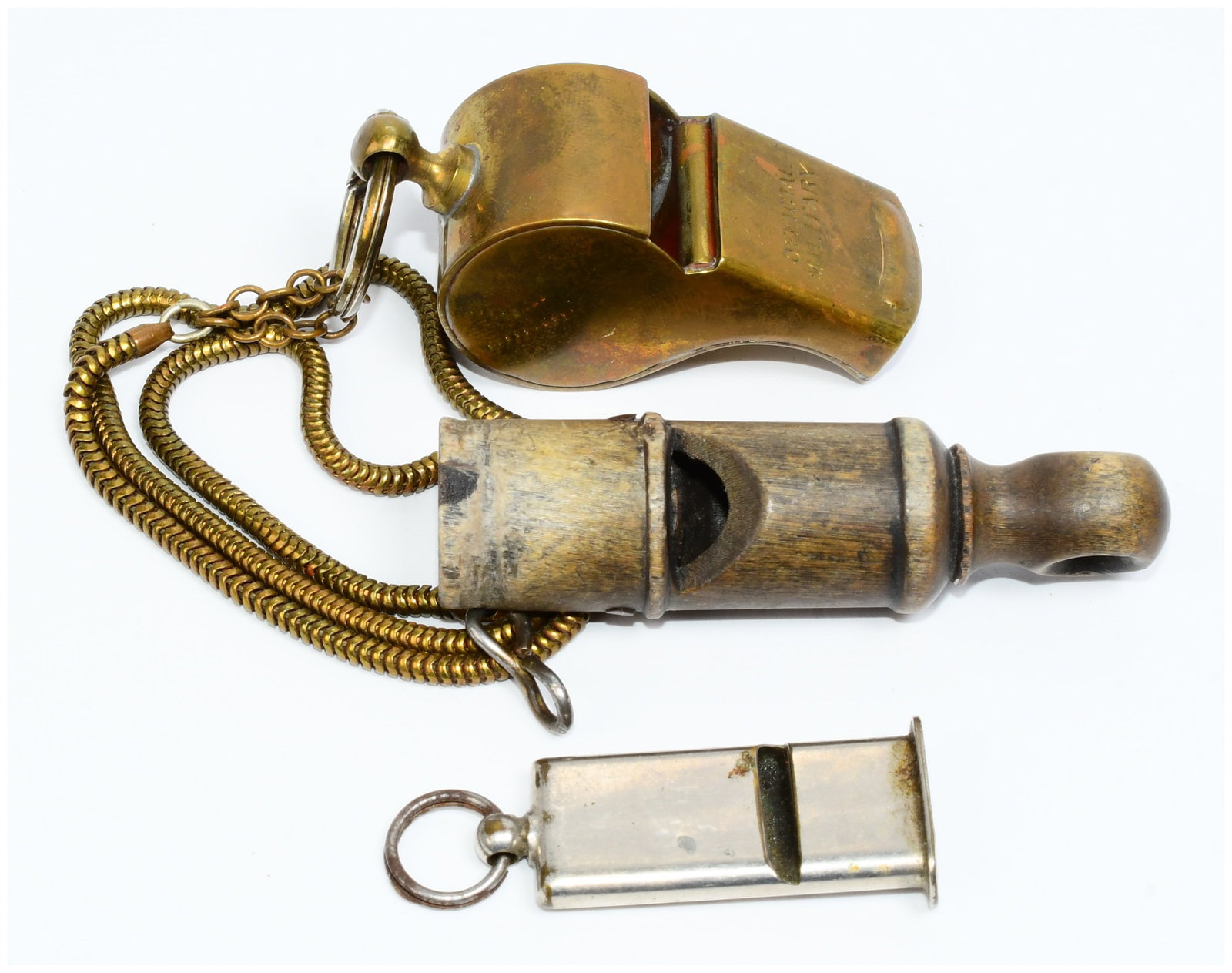 Three Vintage Whistles, including a U.S. Military Brass Pea Whistle: The lot comprises three vintage whistles. The first is a brass "pea" whistle, identified as a U.S. Military type, marked "OFFICIAL MILITARY" on one side, "MADE IN U.S.A." on the reverse, and a partial