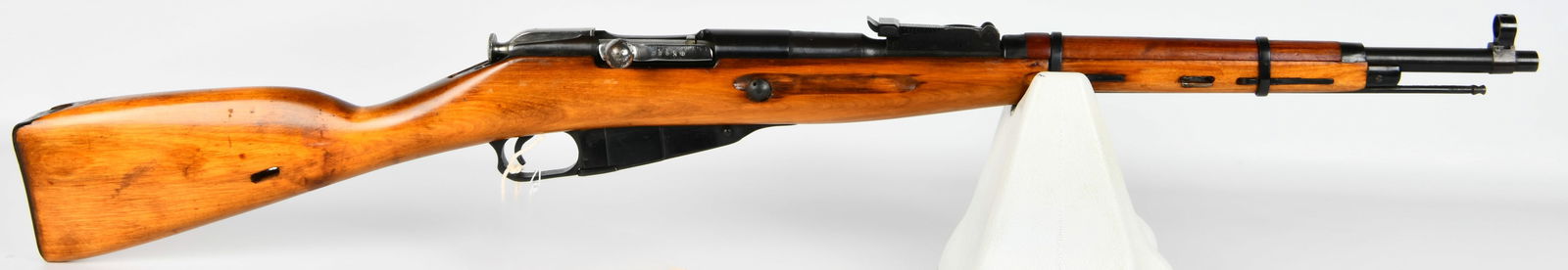 Russian Izhevsk Mosin Nagant M91/59 Bolt Action Carbine, Dated 1941/1959: A Russian Izhevsk Mosin Nagant M91/59 bolt-action military carbine. The light brown wooden stock features a glossy finish, complemented by blued steel metal components. Markings on the receiver includ