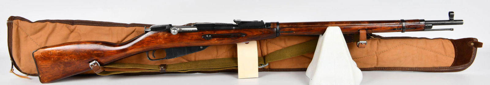 Russian Izhevsk Mosin Nagant M91/30 Bolt-Action Rifle, 1925, with Bucheimer Case: A Russian Izhevsk Mosin Nagant M91/30 bolt-action rifle, dated 1925. The rifle is primarily constructed of blued steel and features a reddish-brown lacquered wooden stock, an external magazine, a stra