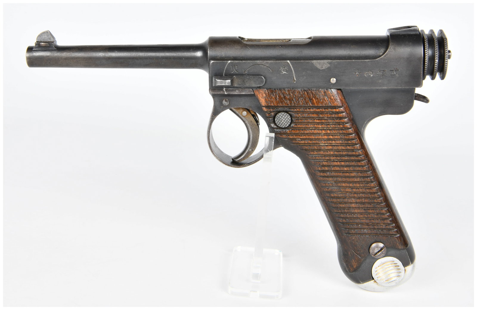 WWII Imperial Japanese Type 14 Nambu Semi-Automatic Pistol: A WWII Imperial Japanese Type 14 Nambu semi-automatic pistol, a notable World War II Pacific Theater sidearm. This dark blued steel pistol features a long barrel, a prominent L-shaped bolt knob, and d