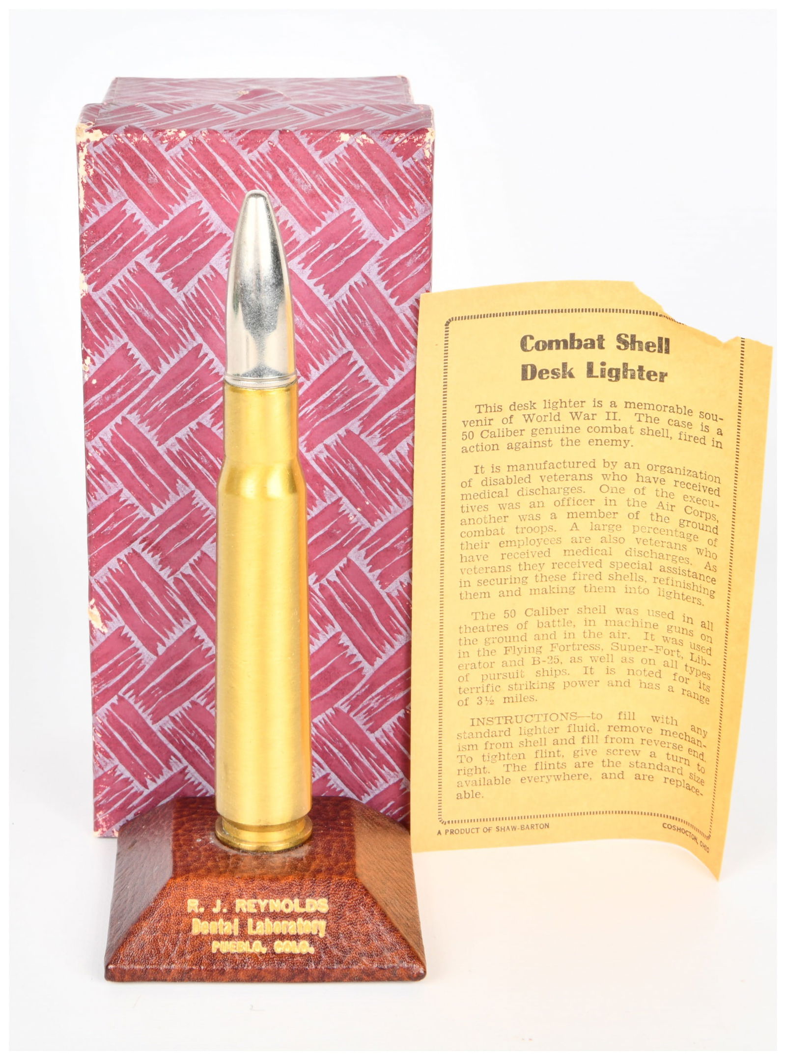 WWII Trench Art .50 Caliber Combat Shell Desk Lighter by Shaw-Barton: A vintage WWII Trench Art .50 Caliber Combat Shell Desk Lighter by Shaw-Barton. This desk lighter is crafted in the form of a .50 caliber bullet, featuring a golden-toned metallic casing resembling a