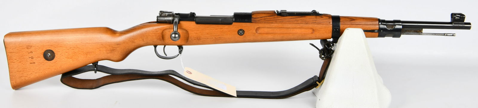 Persian Contract Mauser Model 30 Carbine, Dated 1309 (1930-1931): A Persian Contract Mauser Model 30 Carbine, featuring a bolt-action mechanism. The rifle is constructed with a light-colored wooden stock and blued steel components, accompanied by a leather sling. Th