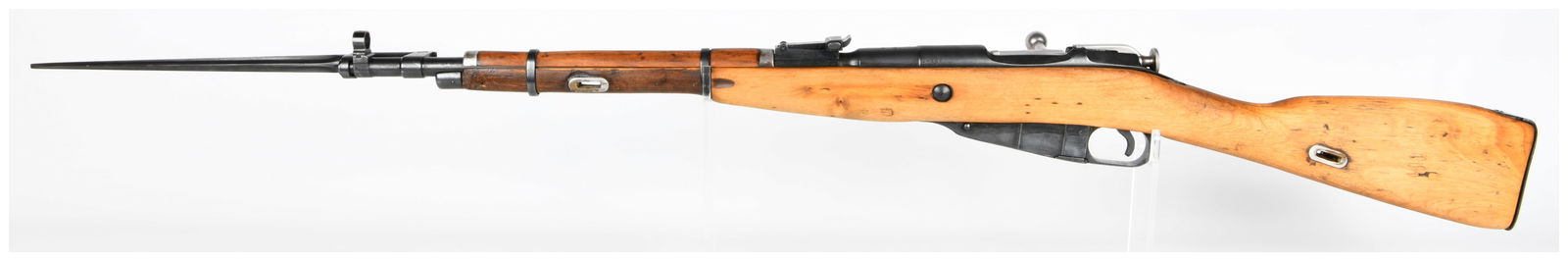Russian Mosin Nagant M44 Bolt-Action Carbine, Dated 1953, Caliber 7.62x54R: A Mosin Nagant M44 bolt-action carbine, featuring a light-colored wooden stock and blued steel components, including an affixed spike bayonet. The receiver is marked with the year "1953", the Cyrillic