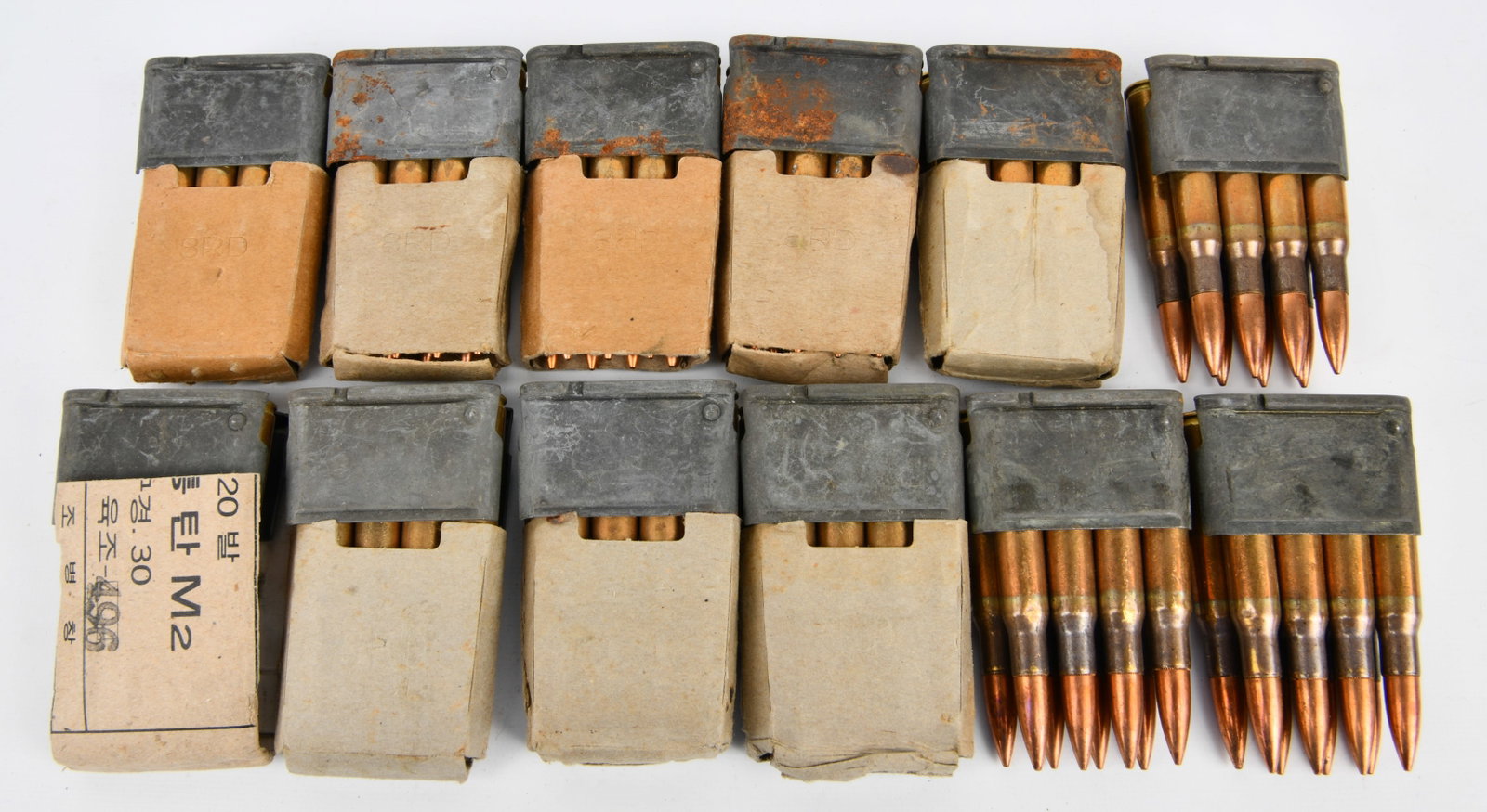 A Group of Korean Military Surplus .30-06 M2 Ammunition on Stripper Clips: A group of Korean Military Surplus .30-06 M2 Ammunition. Comprising twelve bundles, of eight which are presented in partially open cardboard boxes, and two bundles fully loaded on metal stripper clips