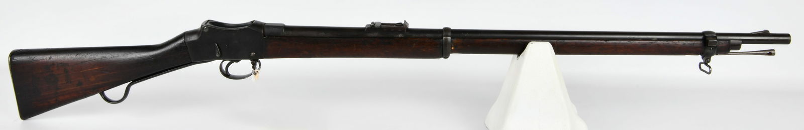 British Martini-Henry Military Rifle, Dated 1902: A British Martini-Henry military rifle, featuring a single-shot, falling-block mechanism. The rifle is constructed from dark blued steel components and a dark-stained wooden stock and forend. The meta