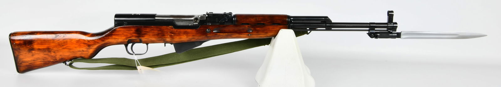 1951 Russian Izhevsk SKS Semi-Automatic Rifle, 7.62x39mm: A 1951 Russian Izhevsk SKS semi-automatic rifle, chambered in 7.62x39mm. The rifle features a reddish-brown lacquered wood stock and handguard, blued steel metal components, and a bright steel folding