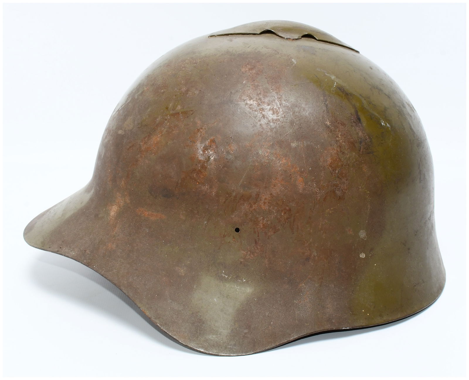 WWII Soviet M36 SSh-36 Steel Combat Helmet: A WWII Soviet M36 SSh-36 steel combat helmet. This military helmet features a dome-shaped crown, a distinctive flared brim, and a unique, riveted metal fin-like crest centrally positioned atop the dom