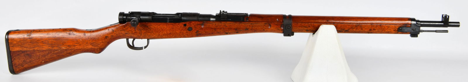 WWII Japanese Type 99 Arisaka Bolt-Action Military Rifle: A World War II era Japanese Type 99 Arisaka bolt-action military rifle, primarily constructed of a stained wooden stock and blued steel metal components. The receiver features visible Japanese charact