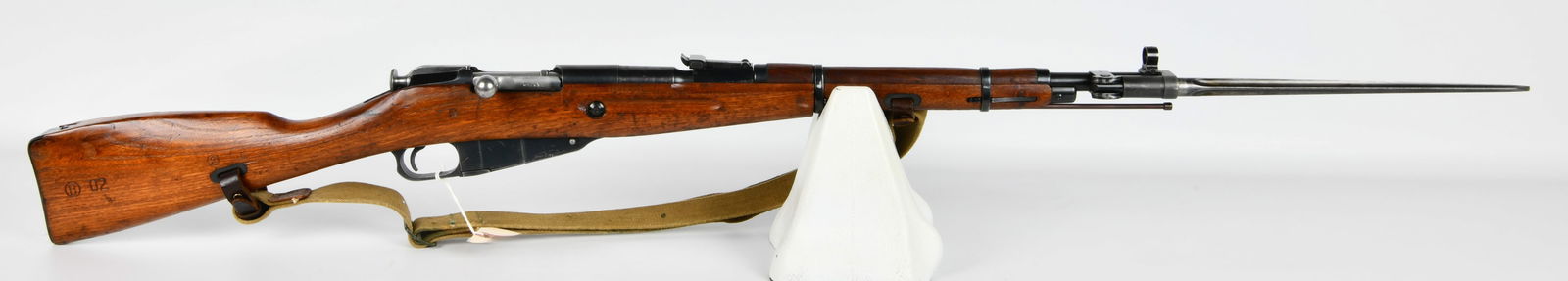 Soviet Mosin Nagant M44 Bolt-Action Carbine, Dated 1953: A Soviet Mosin Nagant M44 bolt-action carbine, dated 1953. This military rifle features a reddish-brown wooden stock and blued steel components, fitted with an integral fixed spike bayonet and a tan c
