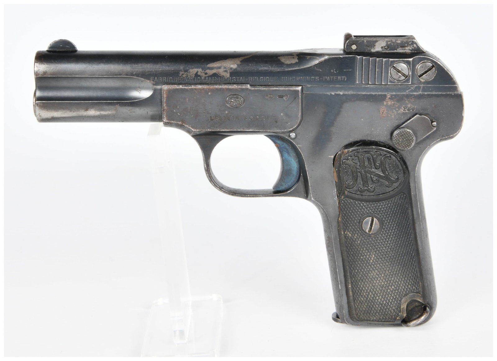 FN Browning Model 1900 .32 ACP Semi-Automatic Pistol: An early 20th-century FN Browning Model 1900 .32 ACP semi-automatic pistol. Constructed of blued steel with checkered hard plastic grip panels embossed with an "FN" monogram. The slide is marked "FABR