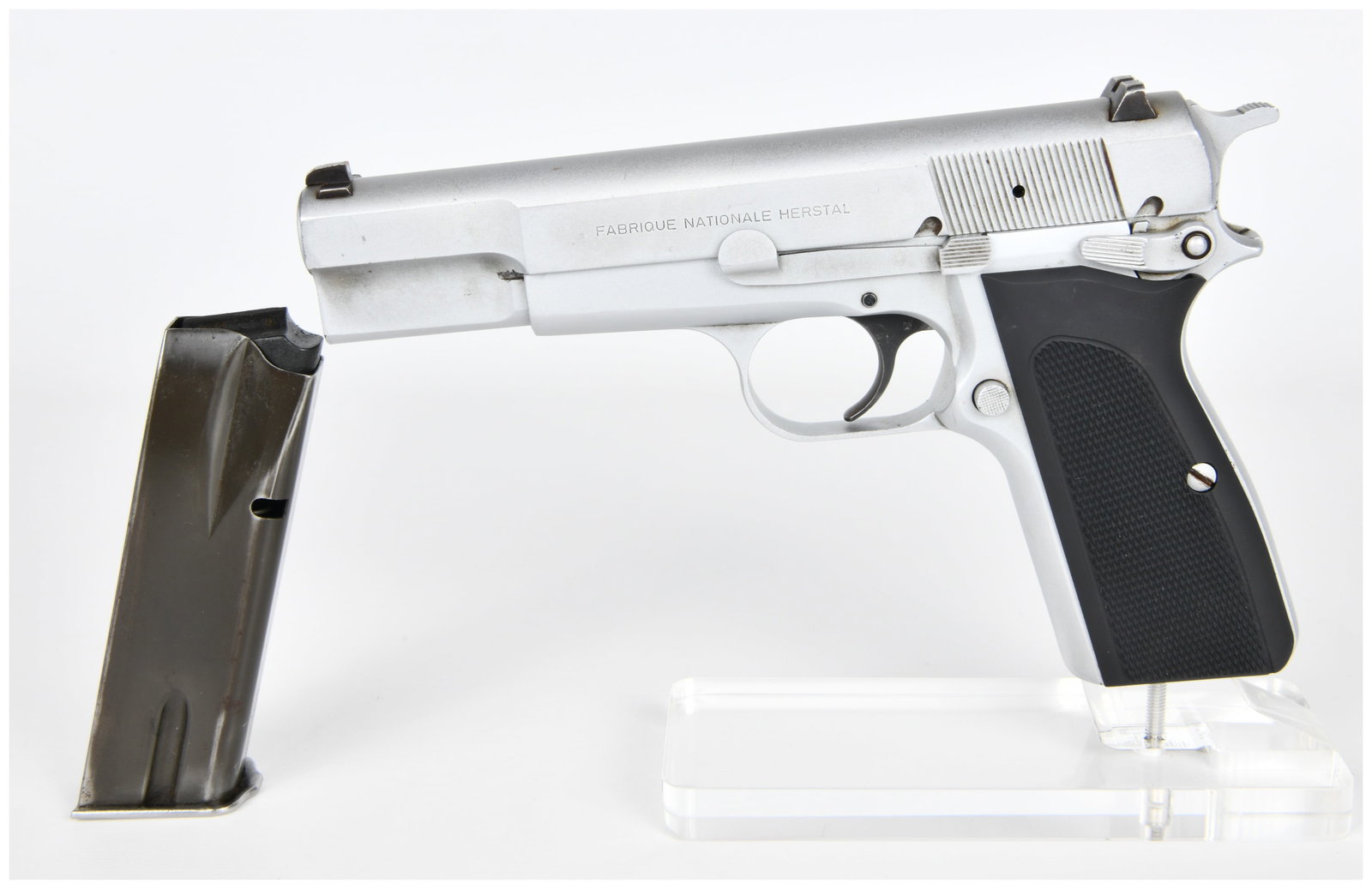 FN Browning Hi-Power Mk-III Semi-Automatic Pistol, 9mm Luger, 1990 Production: An FN Browning Hi-Power Mk-III semi-automatic pistol, chambered in 9mm Luger (9x19mm), featuring a silver-colored metal finish and black checkered polymer or rubber grips. The left side of the slide i