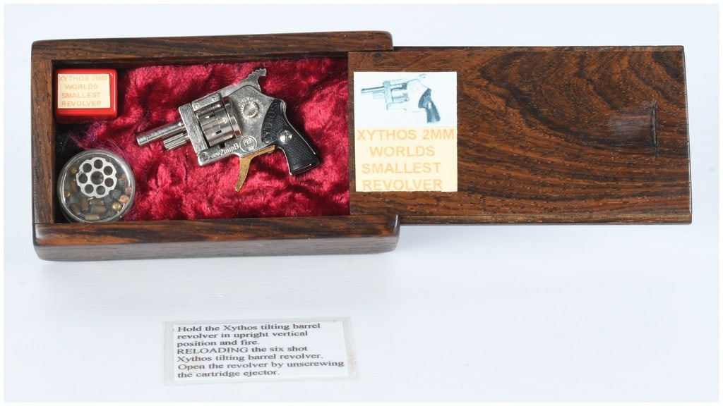 Xythos 2mm Pinfire Revolver 'World's Smallest Revolver' Nickel Finish Cased with Accessories: A Xythos 2mm Pinfire Revolver, marketed as the 'World's Smallest Revolver', with a nickel finish, made in Austria. The miniature revolver is constructed from a silver-toned metal with black checkered