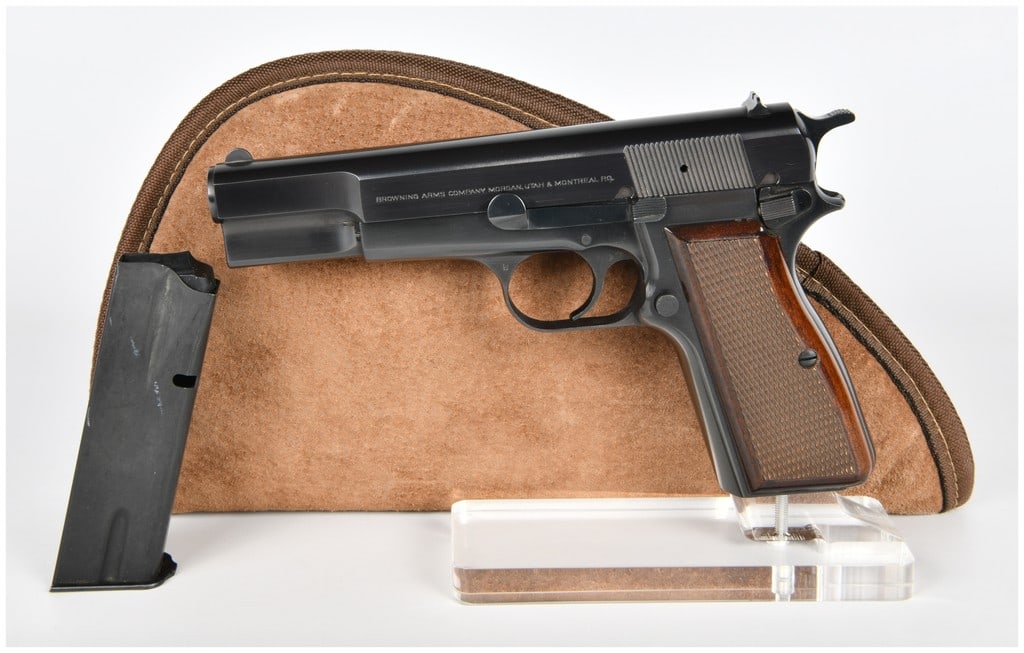 Browning Hi-Power 9mm Semi-Automatic Pistol Belgian Made Circa 1978: A Browning Hi-Power 9mm semi-automatic pistol, manufactured in Belgium by Fabrique Nationale Herstal. The pistol features a blued steel finish and checkered dark wood grip panels. The left side of the