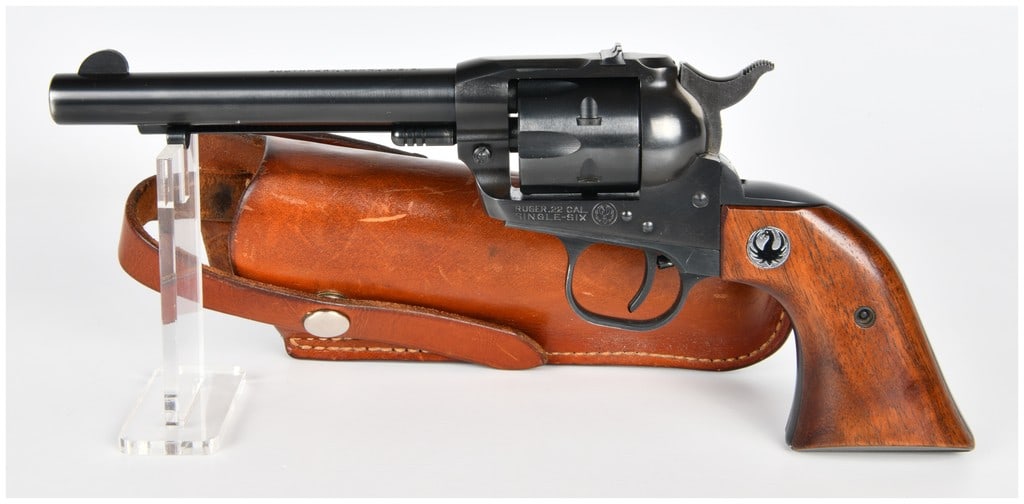 Ruger Single-Six .22 Cal SA Revolver with Bianchi Holster: A Sturm, Ruger & Co. Single-Six .22 caliber single-action revolver, featuring a blued steel finish and fitted with wooden grip panels, each inset with the Ruger phoenix logo. The barrel is marked "STU
