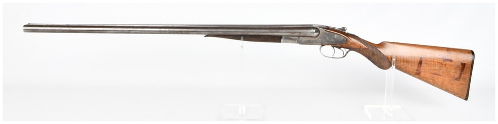 L.C. Smith Field Grade 12 GA Double-Barrel Shotgun Serial No. 33210: An L.C. Smith Field Grade 12 GA double-barrel shotgun. This hammerless, side-by-side shotgun is crafted from blued steel and checkered wood. The manufacturer's name "L. C. SMITH." is clearly engraved