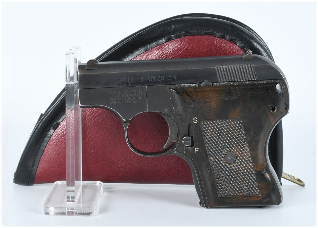 Smith & Wesson Model 61 Escort .22 LR Semi-Automatic Pistol: A Smith & Wesson Model 61 Escort .22 LR semi-automatic pistol. This compact pistol features a blued metal finish and mottled dark brown synthetic grip panels with a checkered pattern. Markings on the