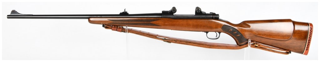 Win Model 70 Bolt-Action Rifle .264 Win. Mag: A Winchester Model 70 bolt-action rifle chambered in .264 Win. Magnum. The rifle features a polished wooden stock with checkered grip panels on the forend and pistol grip. The metal components, includ