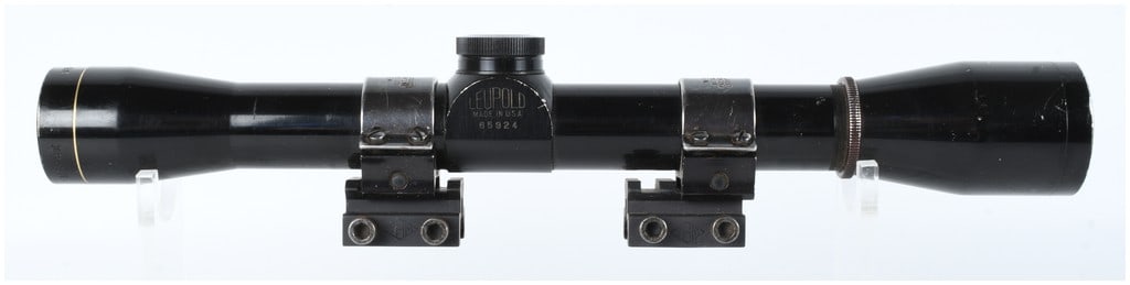 Leupold M8 4X Rifle Scope with Weaver Rings: A Leupold M8 4X telescopic rifle scope featuring a black gloss finish and a signature gold band at the objective lens housing. The main tube is constructed of metal and is marked with LEUPOLD, MADE IN