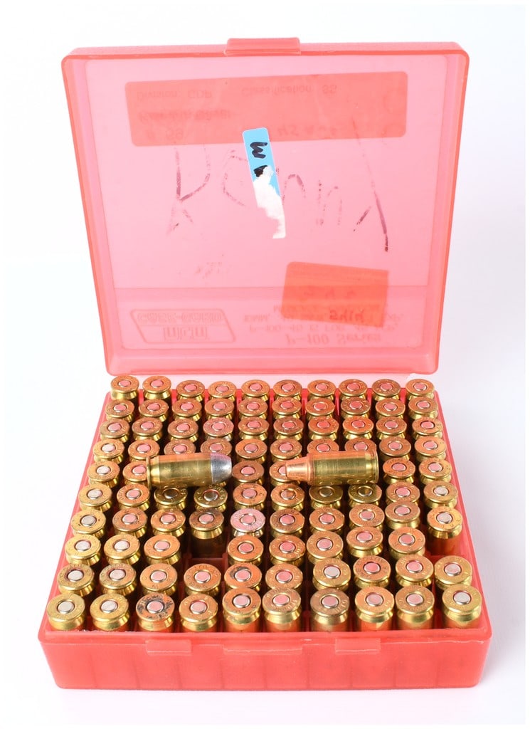 MTM Case-Gard Style Box of 100 Rounds .45 ACP Centerfire Pistol Ammunition, Mixed Components: A collection of 100 centerfire pistol cartridges stored within a translucent red/pink hinged plastic ammunition storage box, consistent with the design of MTM Case-Gard 100-round utility boxes. The