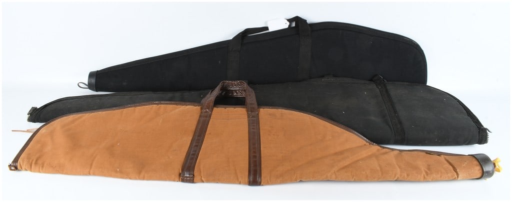 Three Soft Rifle Hunting Cases including Bucheimer: A group of three soft-sided long gun carrying cases in varying styles and materials. The collection includes one tan canvas case featuring dark brown vinyl trim and dual carrying handles, marked with
