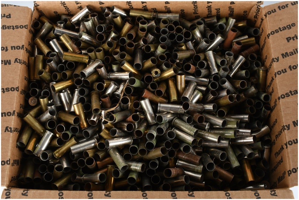 An Assortment of Spent Brass and Nickel-Plated Handgun Ammunition Shell Casings: An assortment of spent ammunition shell casings. The collection consists of various straight-walled handgun calibers manufactured from brass and silver-toned nickel-plated brass. Visible headstamps