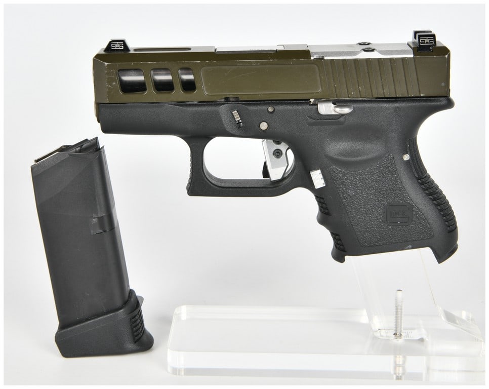 Glock Model 26 Modified Semi-Automatic Pistol, 9x19mm, Custom Slide, Circa 2000s: This lot features a modified Glock Model 26 subcompact semi-automatic pistol chambered in 9x19mm. The firearm is built on a black polymer frame marked MADE IN AUSTRIA and GLOCK, INC., SMYRNA, GA. with