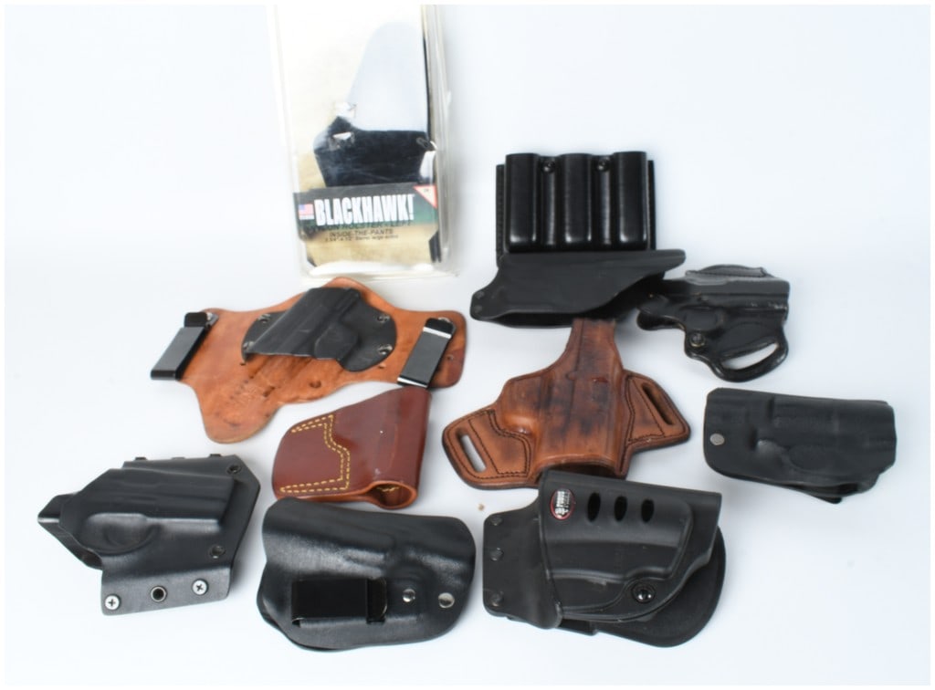 An Assortment of Gun Holsters and Magazine Carriers including Blackhawk Fobus and Galco: An assortment of firearm holsters and accessories featuring various construction materials including molded synthetic polymer, leather, and nylon. The collection includes a Blackhawk nylon inside-the-