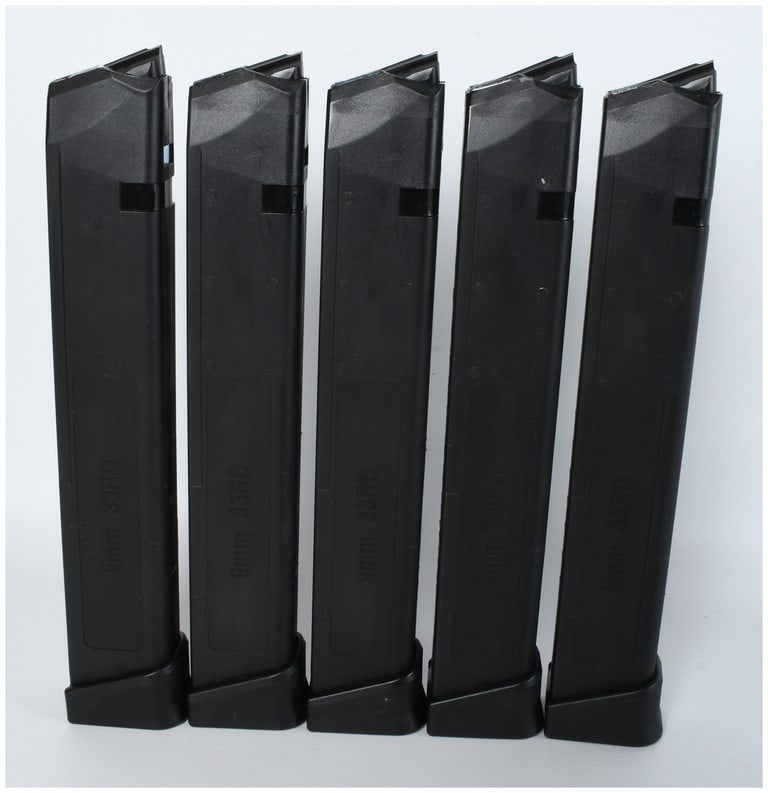 Five 33 Round 9mm Luger Magazines: A group of five extended-capacity handgun magazines designed for Glock-pattern firearms. Each magazine is constructed of a black polymer material featuring a reinforced interior and metal feed lips. T