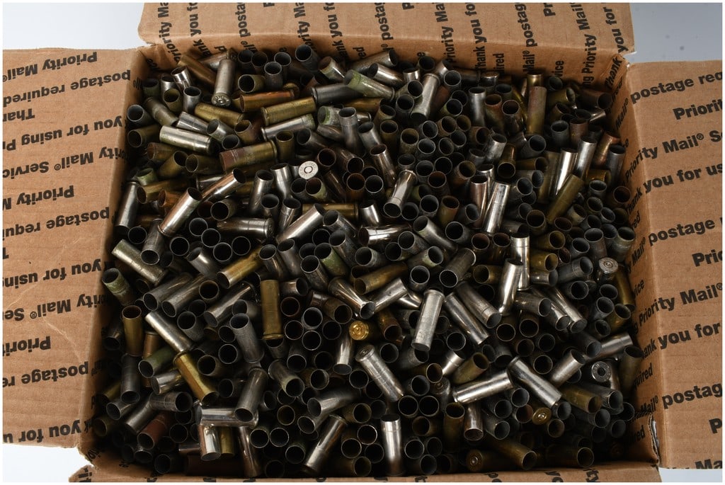 A Collection of 25 LBS of Mixed Caliber Empty Brass Casings: A collection of mixed caliber empty brass casings primarily composed of spent handgun ammunition. The group features a variety of casings constructed from both standard brass and nickel-plated brass.