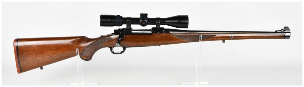 Ruger M77 International Bolt Action Rifle .243 Winchester with 18.5 Inch Barrel: This Ruger M77 International is a bolt action rifle chambered in .243 Winchester, featuring a distinctive full length Mannlicher style checkered walnut stock with a steel forend cap. The rifle is equi