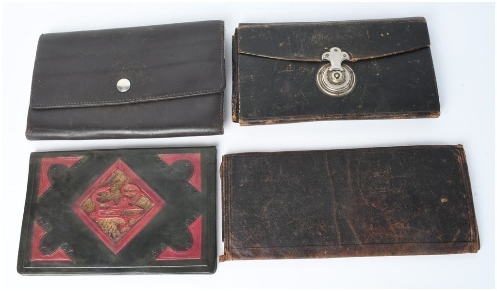 A Collection of 4 Leather Wallets and Document Holders Including Roots Canada: This collection consists of 4 leather items of varying ages and styles. The first item is a contemporary Roots Canada bi-fold wallet crafted from dark brown smooth leather. It features a front flap wi