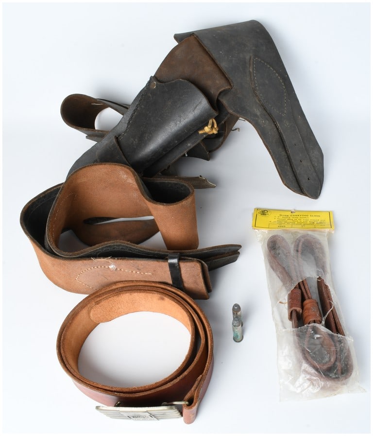 A Group of Vintage Shooting Accessories and Promotional Items: This collection includes a variety of leather shooting accessories and a promotional belt. Featured is a black leather flap holster resembling US military patterns such as the M1851 or M1878, alongsid
