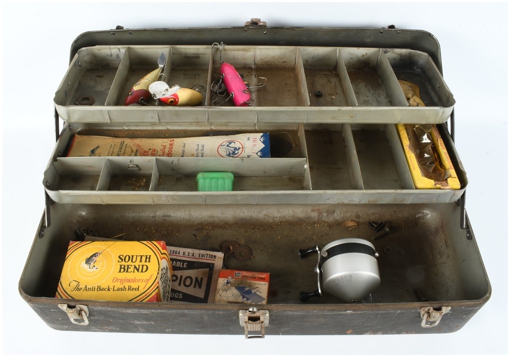 A Collection of Vintage Fishing Tackle and Related Ephemera in a Metal Tackle Box: This lot comprises a vintage metal tackle box containing an assortment of mid-20th-century fishing equipment and related items. The tackle box features a dark-toned exterior with a gray interior and t