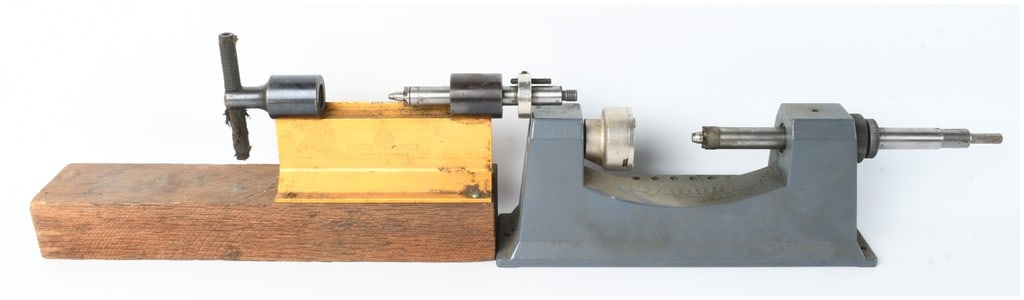 Two Bench-Mounted Ammunition Case Trimmers by Forster Appelt and Lyman: This lot consists of two vintage bench-mounted ammunition reloading tools used for case trimming. The first unit is a Forster Appelt case trimmer featuring a yellow-painted metal base mounted to a woo