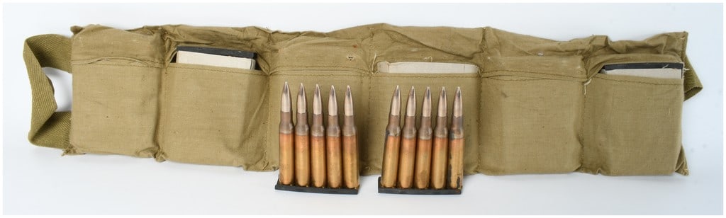 A Lot of 60 Rounds of .30-06 Springfield Ammunition on Stripper Clips in Canvas Bandolier: This lot consists of sixty rounds of .30-06 Springfield ammunition, organized on twelve five-round metal stripper clips and housed within a khaki-colored cotton canvas shoulder bandolier. The ammuniti