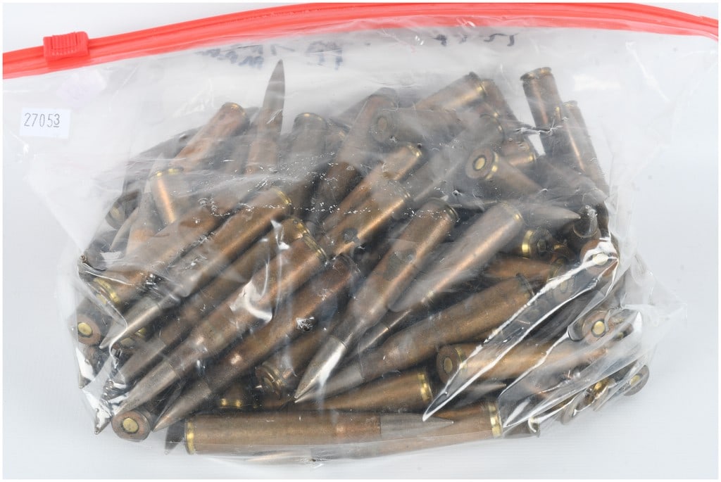 A Lot of 100 Rounds of Fabrique Nationale 7mm Mauser Ammunition 1946-1954: This bulk lot consists of 100 rounds of 7mm Mauser military-surplus centerfire rifle ammunition. The cartridges are configured with bottlenecked brass cases and silver-colored spitzer projectiles, lik