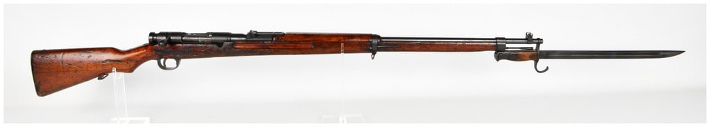 Japanese Kokura Arsenal Type 38 Bolt Action Rifle 6.5x50mmSR with 31.5 Inch Barrel: This Japanese Type 38 Arisaka bolt-action rifle is chambered in 6.5x50mmSR and is configured with a 31.5-inch barrel. The rifle features a blued finish on the receiver and barrel, which is mounted in 