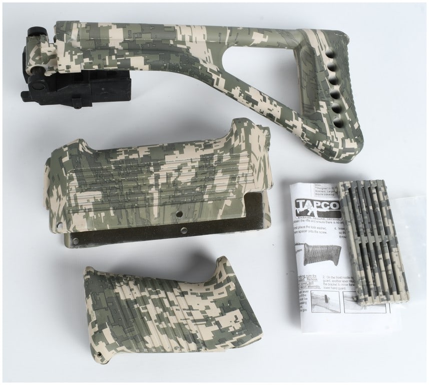 TAPCO AK-Style Digital Camouflage Polymer Furniture Set: A set of TAPCO brand polymer furniture for an AK-style rifle, finished in a digital camouflage pattern of green, tan, and brown. The collection includes a side-folding stock with an integrated black c
