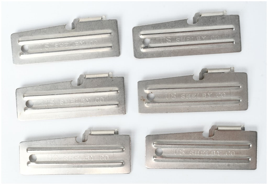 A Set of Six US Shelby Co Military Folding Can Openers: A set of six military folding can openers manufactured by the Shelby Co. These tools, widely recognized by the designations P-38 and P-51, served as a standard piece of field equipment for members of