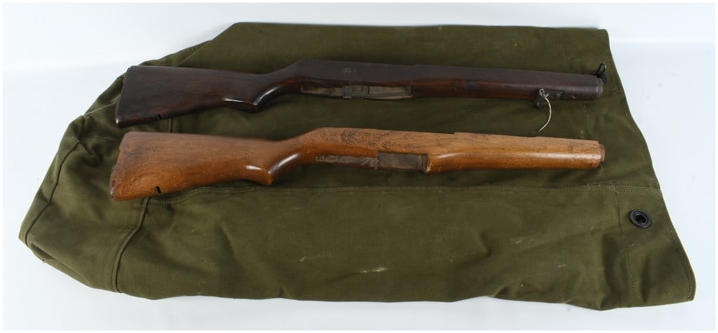 A Pair of US Military M1 Carbine Wooden Stocks with Canvas Bag: This lot consists of two wooden stocks designed for the US .30 caliber M1 Carbine and one large olive drab canvas equipment bag. The first stock is crafted from dark-stained walnut and features a low 