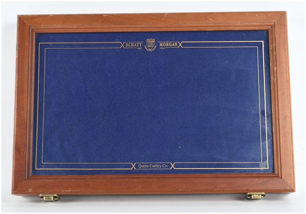 Queen Cutlery Co. Schatt and Morgan Centennial Commemorative Knife Display Case: A rectangular wooden display case manufactured by Queen Cutlery Co. to commemorate the 100th anniversary of Schatt and Morgan, spanning the dates 1902 to 2002. The case is constructed from solid wood 