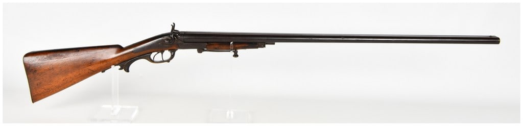A. Artmann Side-By-Side Under-Lever Hammer Shotgun Antique: This is a German-manufactured side-by-side hammer shotgun featuring a break-action design and a double-trigger configuration. The firearm utilizes an under-lever opening mechanism positioned below the